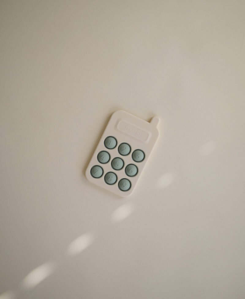 Mushie pop it žaislas - telefonas „Cambridge Blue“
